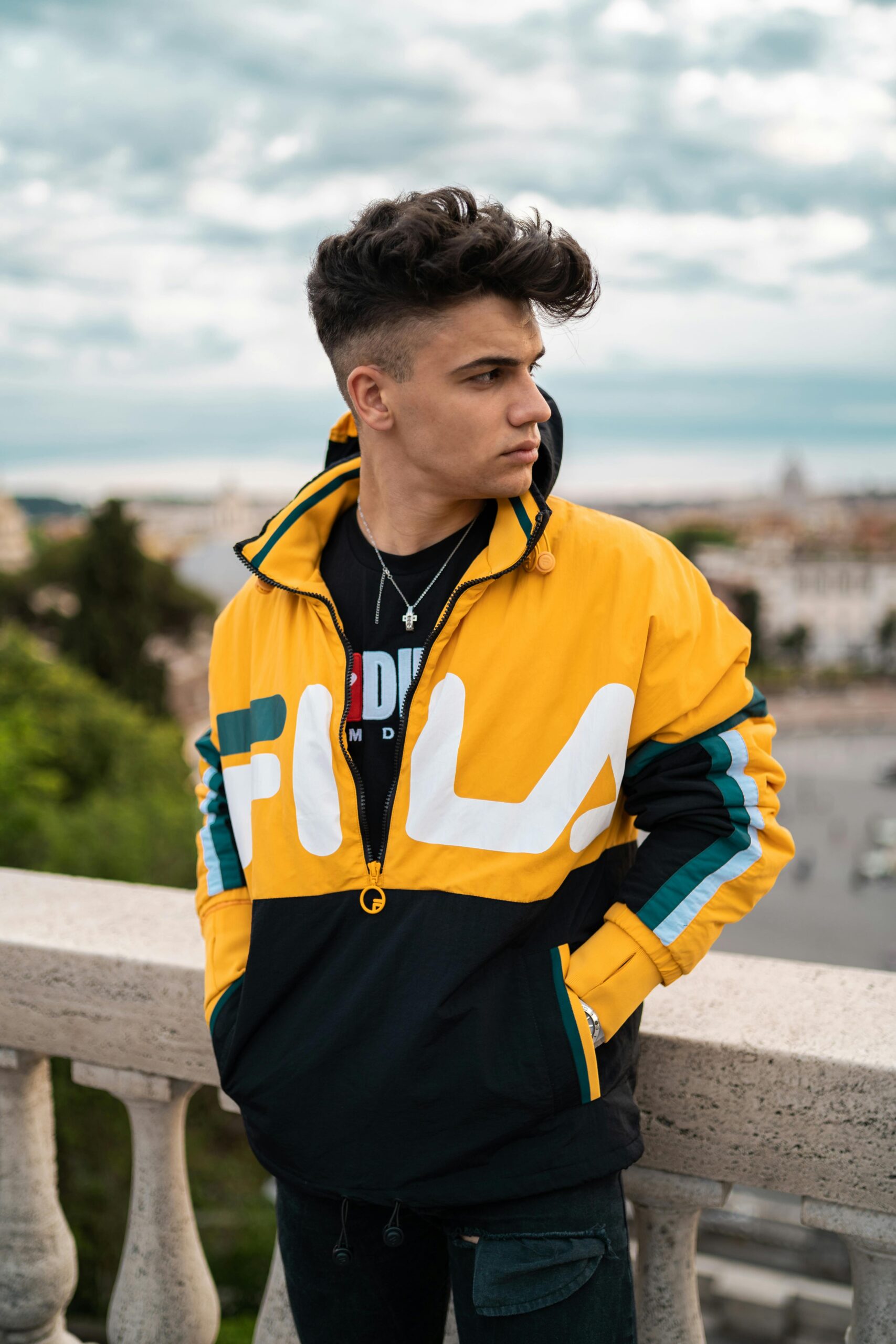 Casual portrait of a fashionable young man in Rome, Italy with a city view.